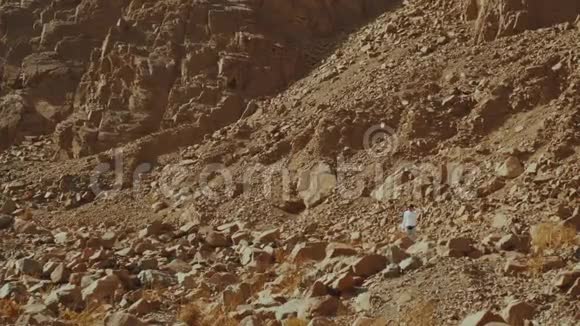 游客在炎热的沙漠中沿着岩石峡谷散步沙漠岩石背景埃及西奈慢运动4k视频的预览图