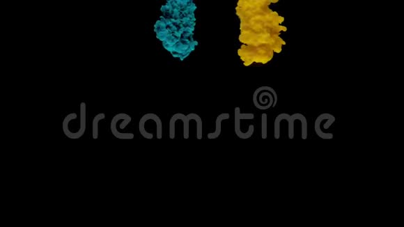 五颜六色的绿松石和黄色的墨水从上面混合在水中轻轻地在黑色背景下旋转视频的预览图