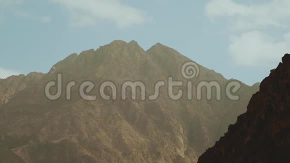 一群游客在炎热的沙漠中沿着岩石峡谷散步沙漠峡谷背景埃及西奈慢动作4k视频的预览图
