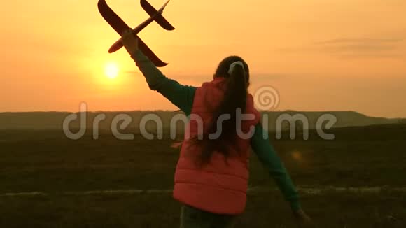 一个孩子玩玩具飞机女孩梦想飞行并成为飞行员慢动作快乐女孩带着玩具跑视频的预览图