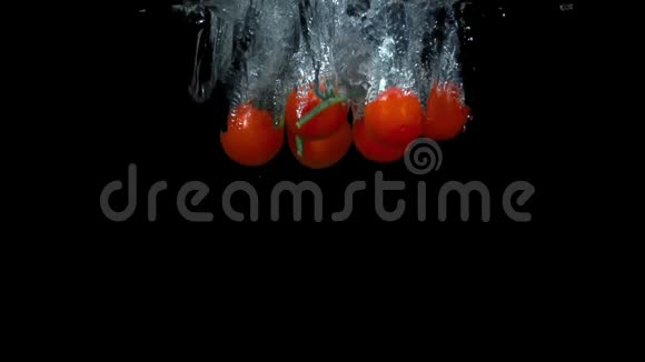 樱桃番茄落在水中的黑色背景视频的预览图