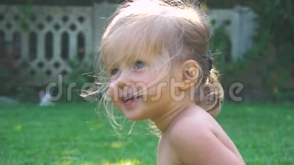 小女孩在草坪上慢动作嬉戏的肖像视频的预览图