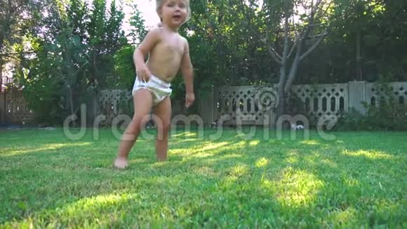小女孩在草坪上旋转奔跑跌倒视频的预览图