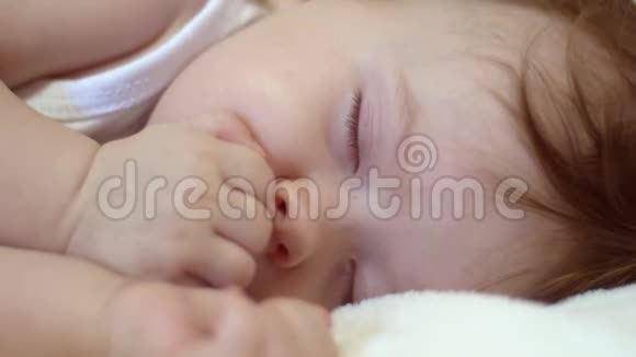小婴儿睡在婴儿床上用拳头握着小手视频的预览图