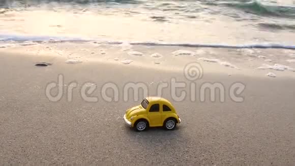 旅行和度假玩具黄车在沙滩上靠海视频的预览图