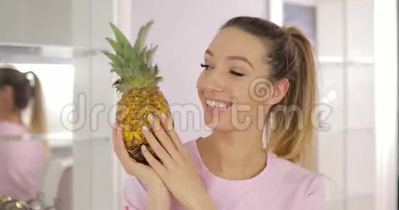 年轻风趣的女人在厨房里玩菠萝视频的预览图