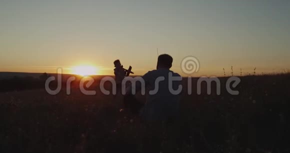 美丽惊人的日落爸爸和儿子一起玩飞机梦爸爸鼓励他当飞行员视频的预览图