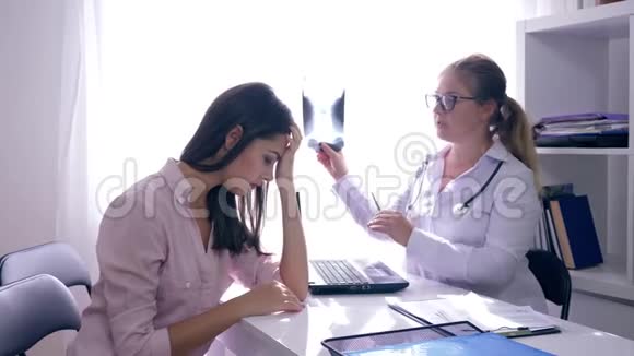妇女健康医生手里拿着x光然后支持医务处的妇女病人视频的预览图