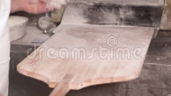 面包师用铲子倒面粉准备在面包店烤面包视频的预览图