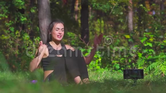 年轻的黑发女性博客作者在阳光林慢动作中做运动视频的预览图