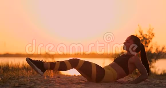 健身女人在海滩上做仰卧起坐健身妇女做仰卧起坐运动锻炼到海滩女性视频的预览图