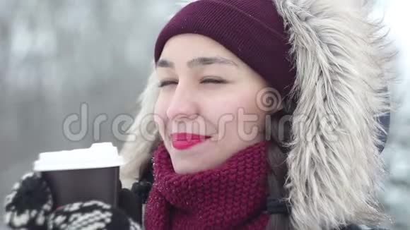美丽的年轻女孩在雪地公园享受冬天的景色和喝咖啡视频的预览图