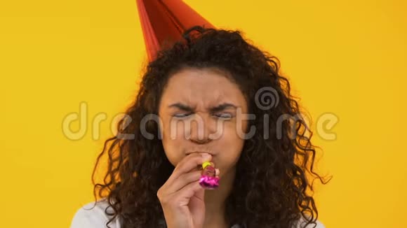 快乐的女孩吹着派对的号角庆祝生日背景被孤立了视频的预览图