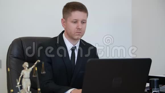专心致志的律师在他的工作台上用他的笔记本电脑视频的预览图