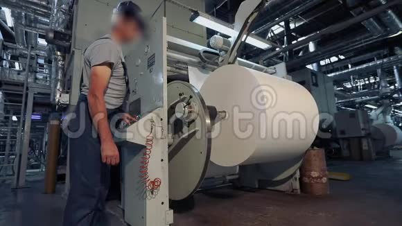 一个人站在工厂里生产壁纸工厂里一个人控制着机器视频的预览图