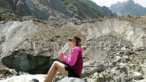 女游客从山里的瓶子里喝水视频的预览图