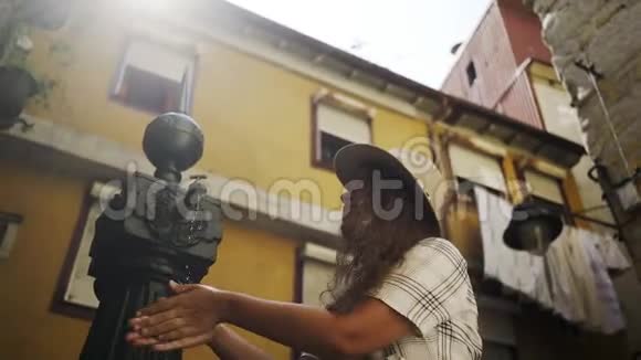 微笑的女人尿手在街边的喷泉里视频的预览图