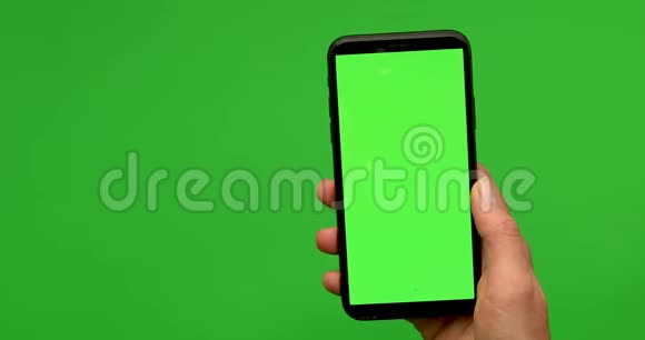 女人手拿着一部带有greeen屏幕的智能手机视频的预览图