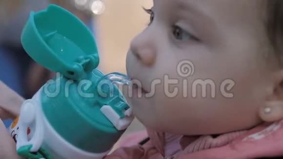 可爱的小女孩从瓶子里喝水视频的预览图
