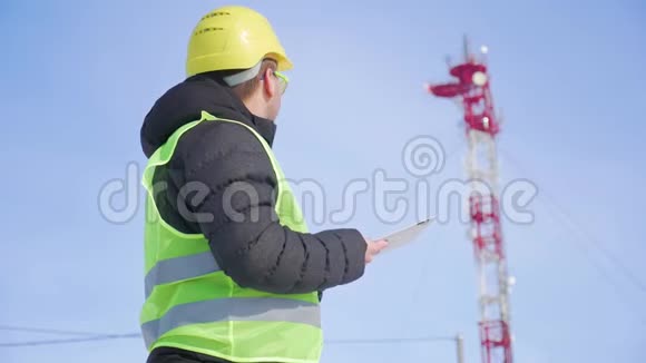 从事数字平板电脑工作的工程师在电信塔上有卫星天线电信网络视频的预览图
