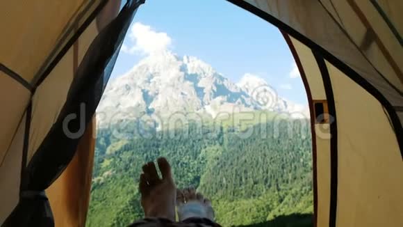 露营女孩展示了从洛基山背景帐篷的近脚视频的预览图