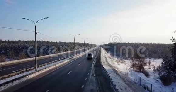 冬季道路上有交通车和卡车的高速公路的鸟瞰图视频的预览图