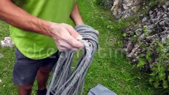 年轻的男性冒险登山者准备绳索攀登岩石极端墙视频的预览图