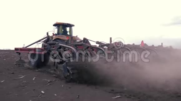 春季耕作农田的过程现代拖拉机在农田上作业视频的预览图