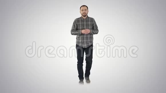年轻自信的男人穿着衬衫和牛仔裤朝相机走去在渐变背景上指着两边视频的预览图
