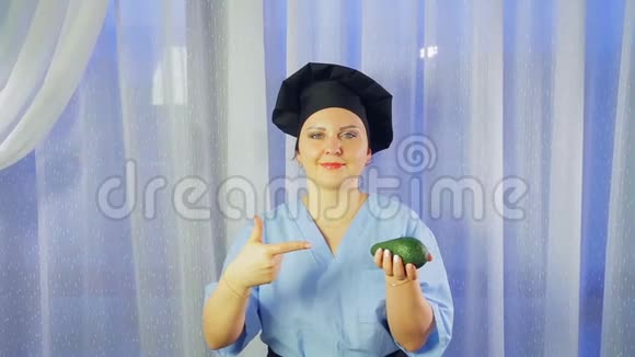 一位女厨师微笑着手里拿着一个鳄梨指着它视频的预览图