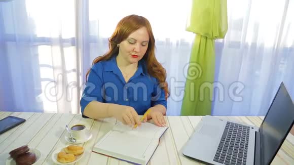 一个棕色头发的女人在一张桌子的咖啡馆里写日记喝咖啡视频的预览图