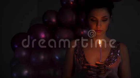 穿紫色衣服的年轻女子吹蜡烛视频的预览图
