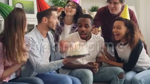 快乐的非裔美国人在生日蛋糕上吹蜡烛在家笑视频的预览图
