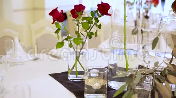 一家餐馆桌子上的花瓶里放着三朵红色的茂盛的玫瑰视频的预览图