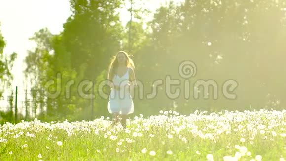 美丽的女孩奔跑在太阳日落的夏日蒲公英田野上玩得很开心自由健康幸福年轻快乐视频的预览图