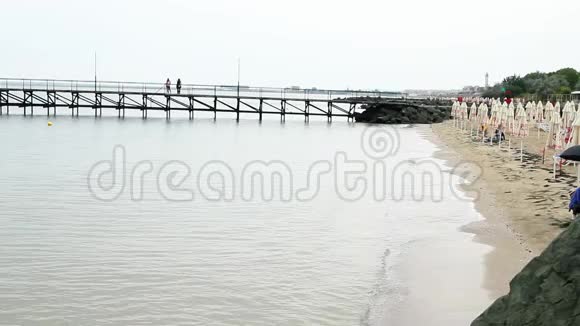 寂寞的海滩度假者漫步在码头视频的预览图