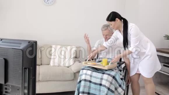 护士为坐轮椅的残疾人带来早餐视频的预览图