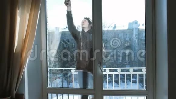 男人在阳台上给自己家里的脏窗户洗澡视频的预览图