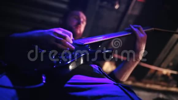 一个摇滚乐队的人在舞台上弹吉他下面的视图视频的预览图