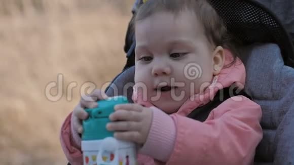 可爱的小女孩从瓶子里喝水视频的预览图