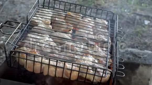 露天烧烤那个人在煤上用多汁的肉把烤架转动快关门从上面看到的4k视频的预览图