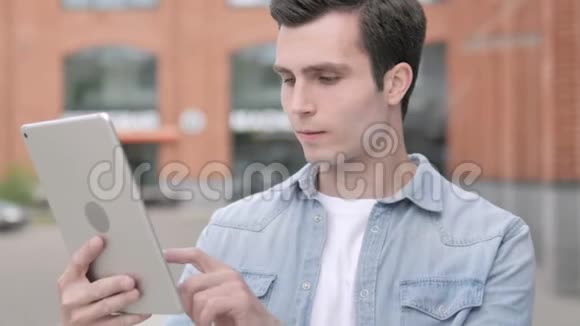 站在户外的年轻人在平板电脑上视频聊天视频的预览图