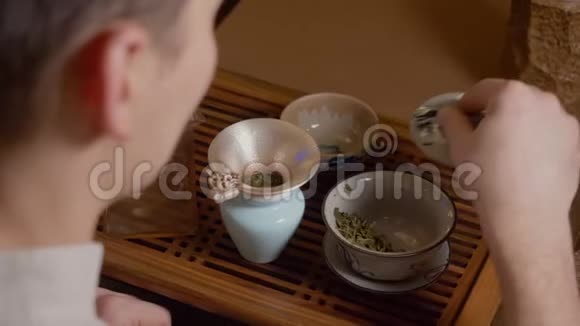 茶师从水壶往盖湾倒热水从热杯中蒸出来绿茶视频的预览图