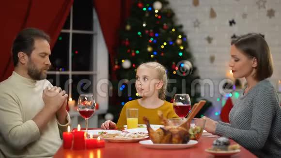 传统家庭在吃圣诞晚餐前祈祷信仰上帝基督教视频的预览图