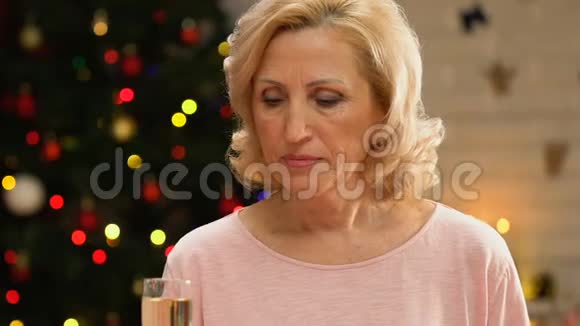 沮丧的老年妇女独自在圣诞节喝香槟失踪的孩子视频的预览图