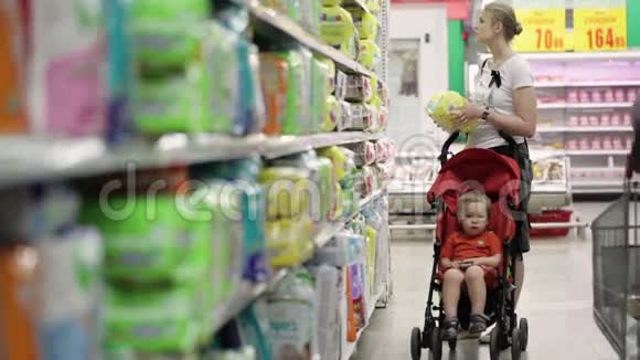 妈妈和她的孩子在超市里坐婴儿车视频的预览图