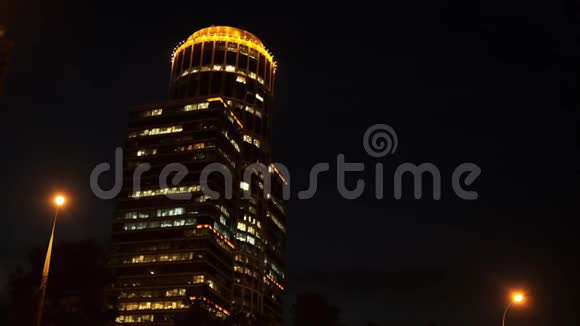 从高现代住宅建筑底部看顶部有橙色照明黑色晴朗的夜晚视频的预览图