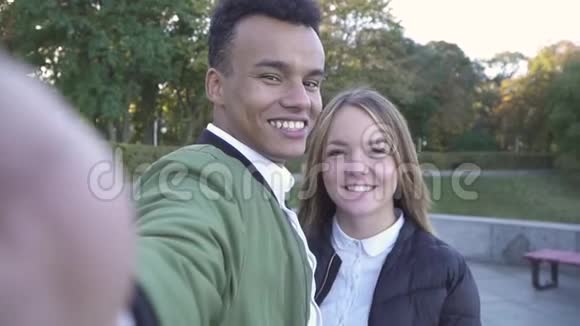 亲吻十几岁的跨种族夫妇在镜头上拍摄自己视频的预览图