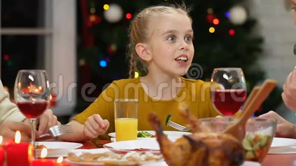 小女孩在圣诞晚宴上和父母交流家庭庆祝活动视频的预览图