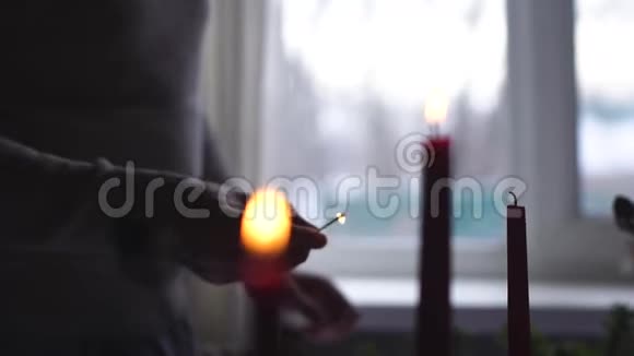 男性手在窗户的背景下缓慢地点燃蜡烛视频的预览图